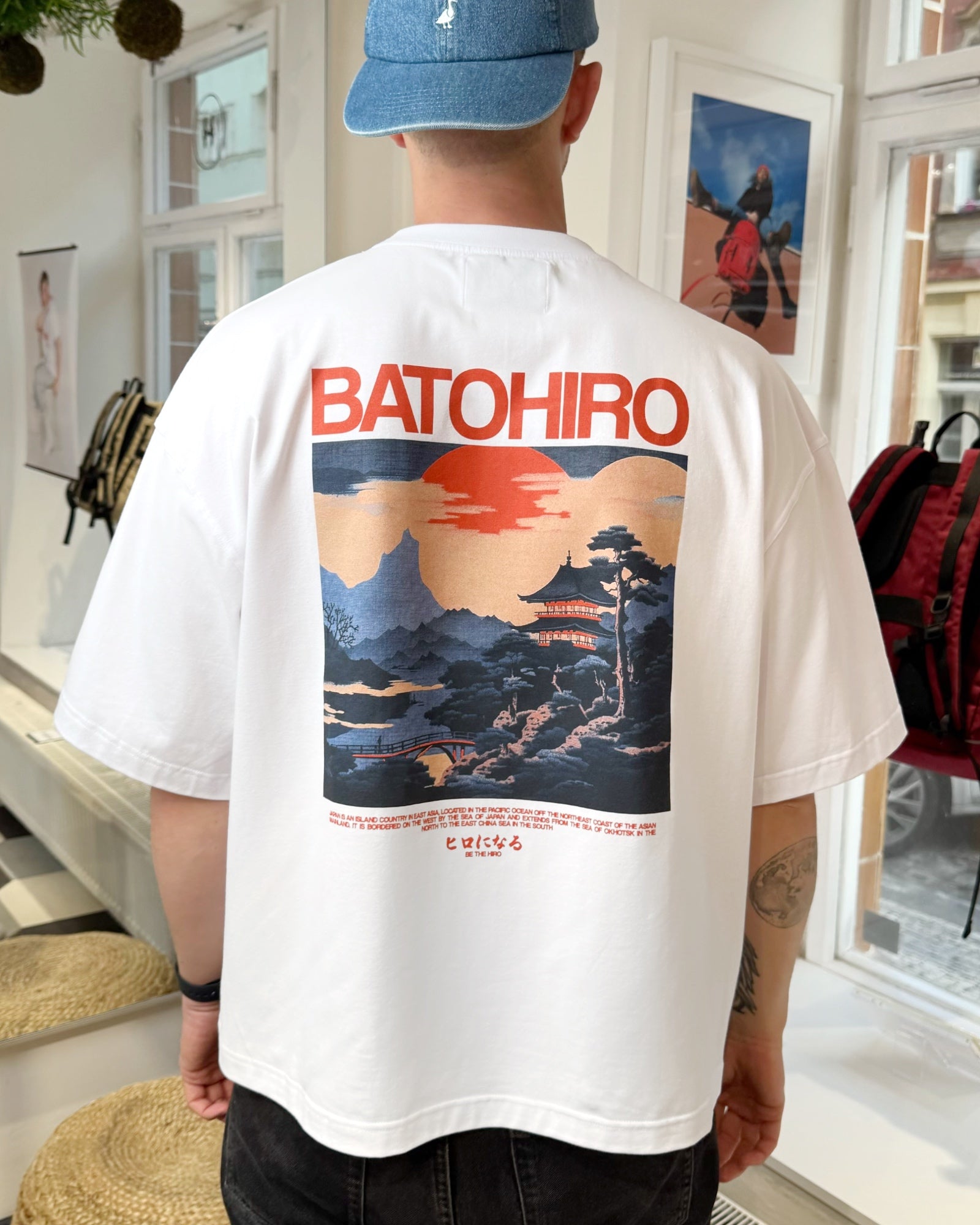 Man in Hiro Wave cropped oversized tee with Batohiro design, standing in a shop.