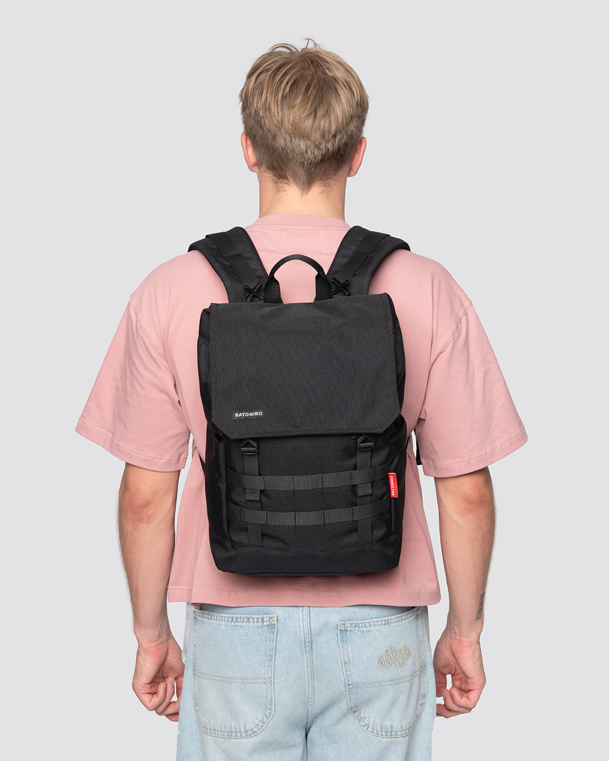 Person wearing a stylish black backpack with adjustable straps and spacious design, perfect for everyday use.