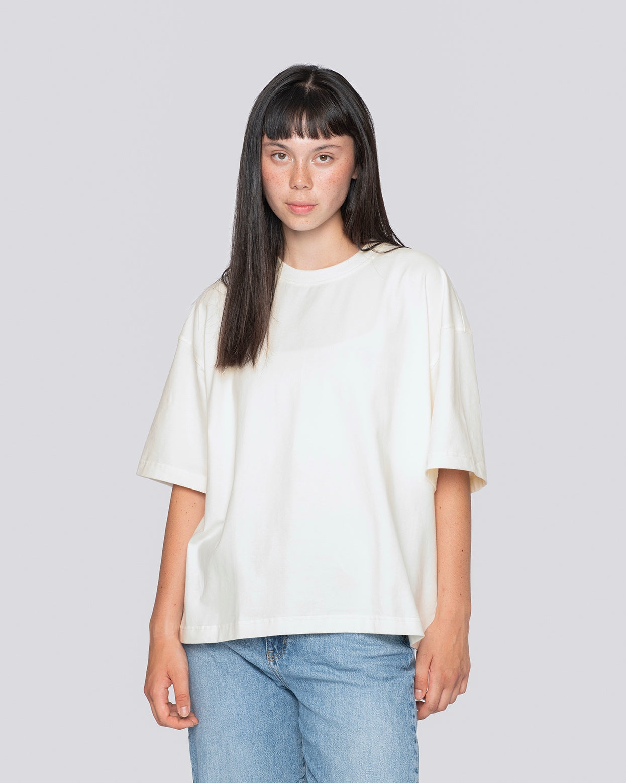 Woman wearing cream cropped oversized tee by Batohiro, crafted from cotton with elastane, showcasing loose fit and Czech handmade quality.