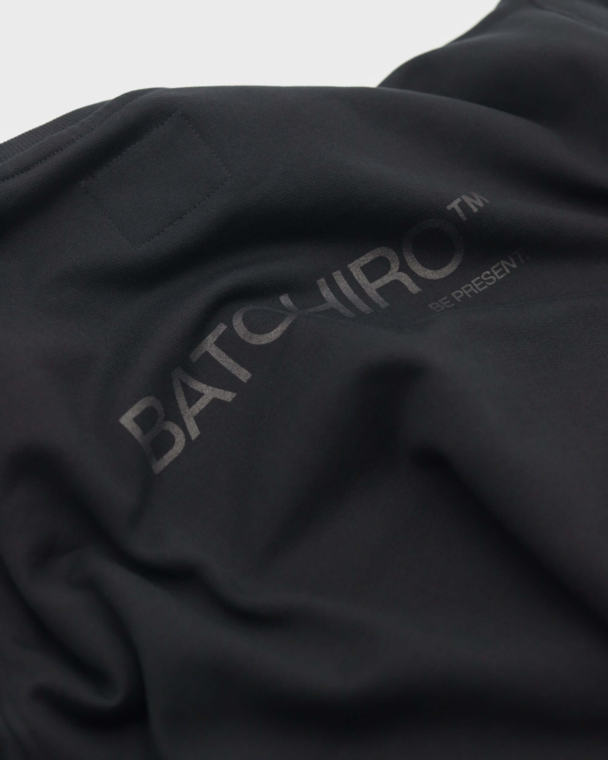 Detail black crewneck sweatshirt with batchiro logo and texture, černá mikina bez kapuce.