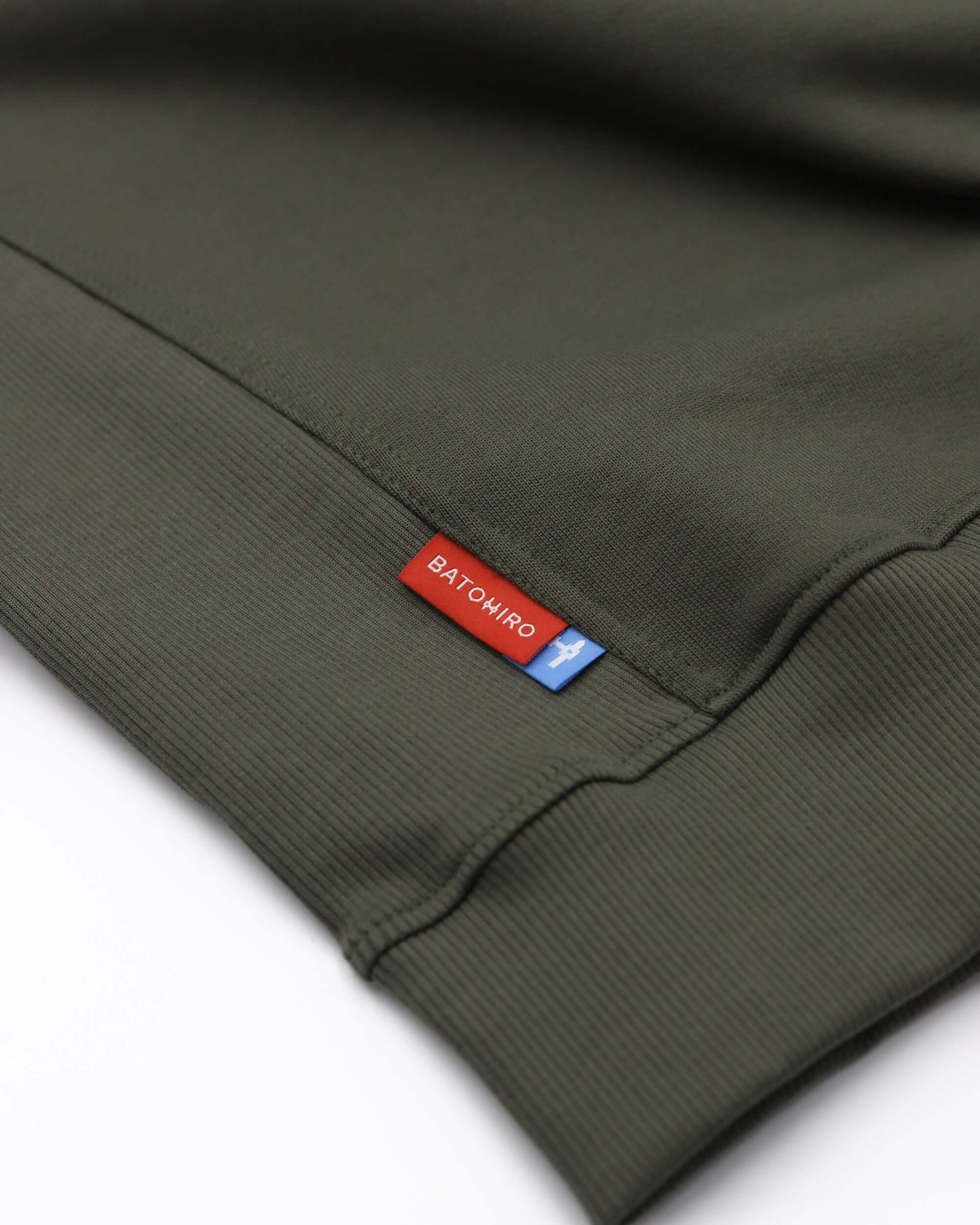 Detail of Batohiro 343 zelená mikina crewneck showing tag and fabric texture.